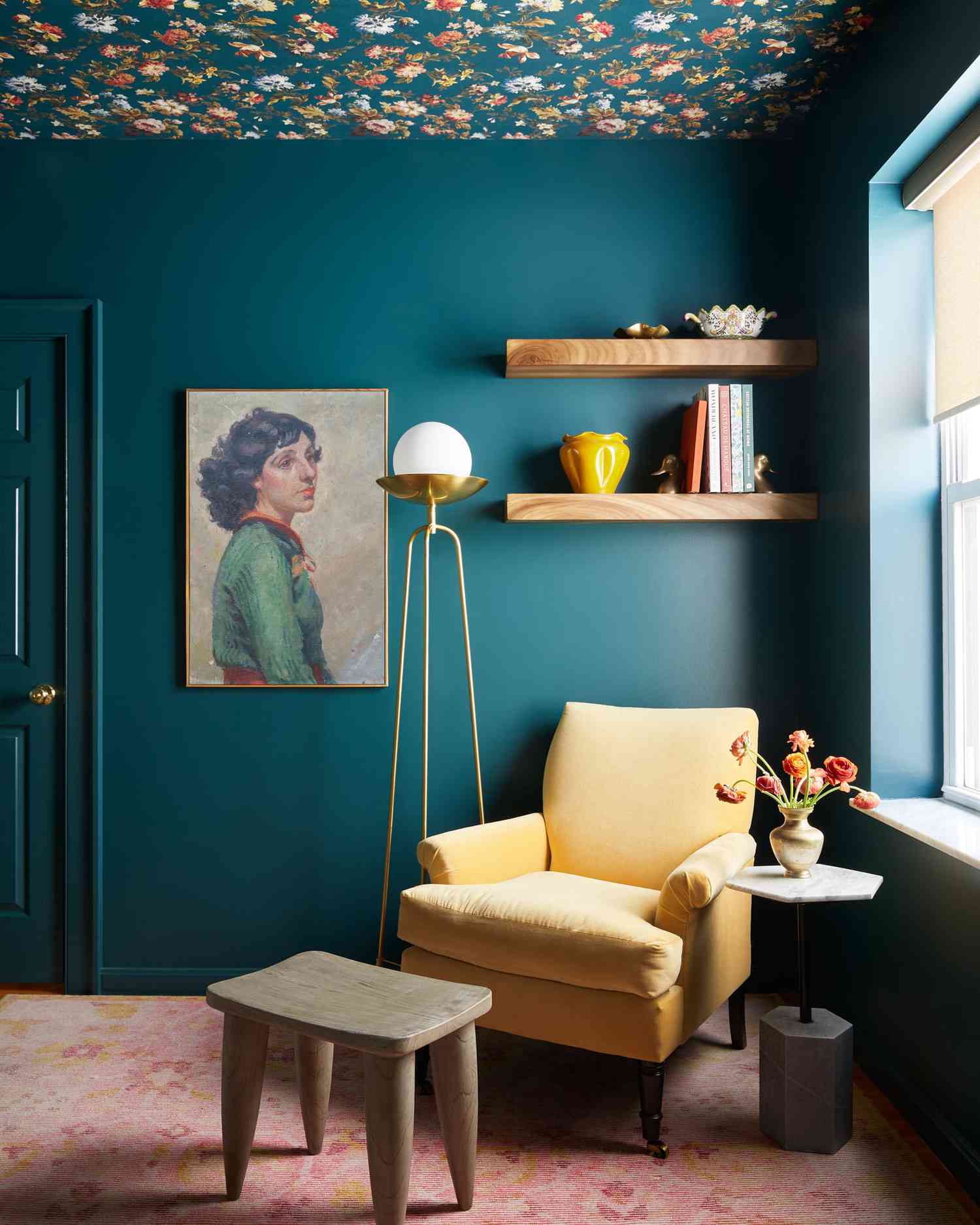 Deep teal reading nook with decorative wallpaper ceiling